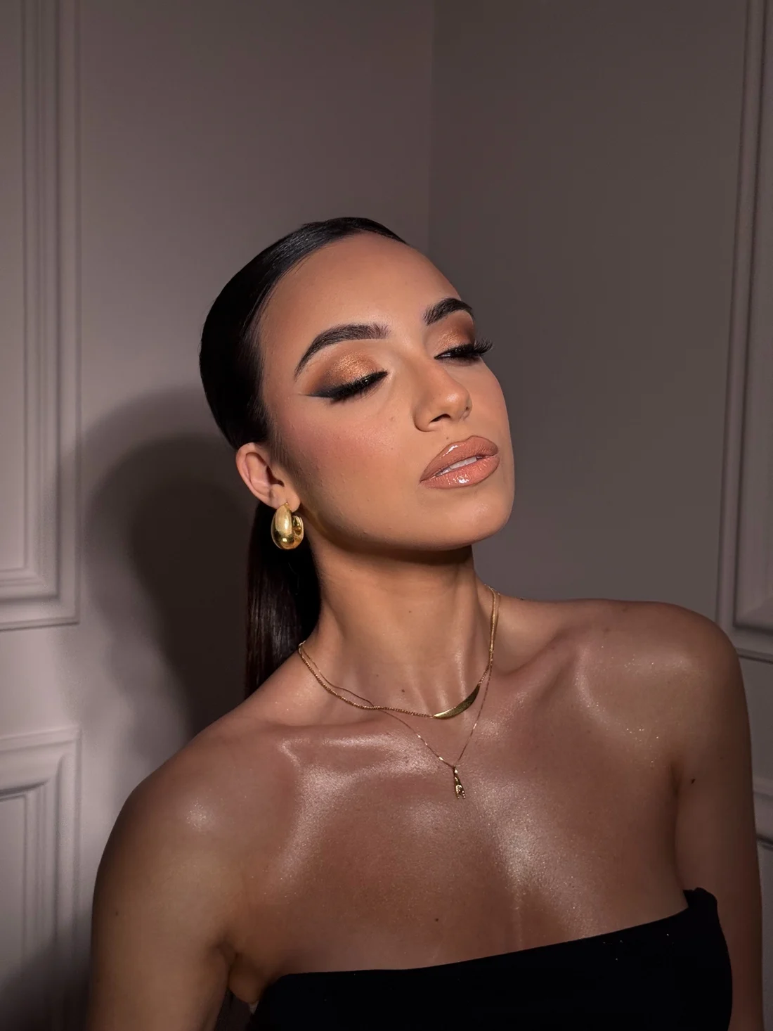 Makeup bronzo con eyeliner sfumato e capelli raccolti